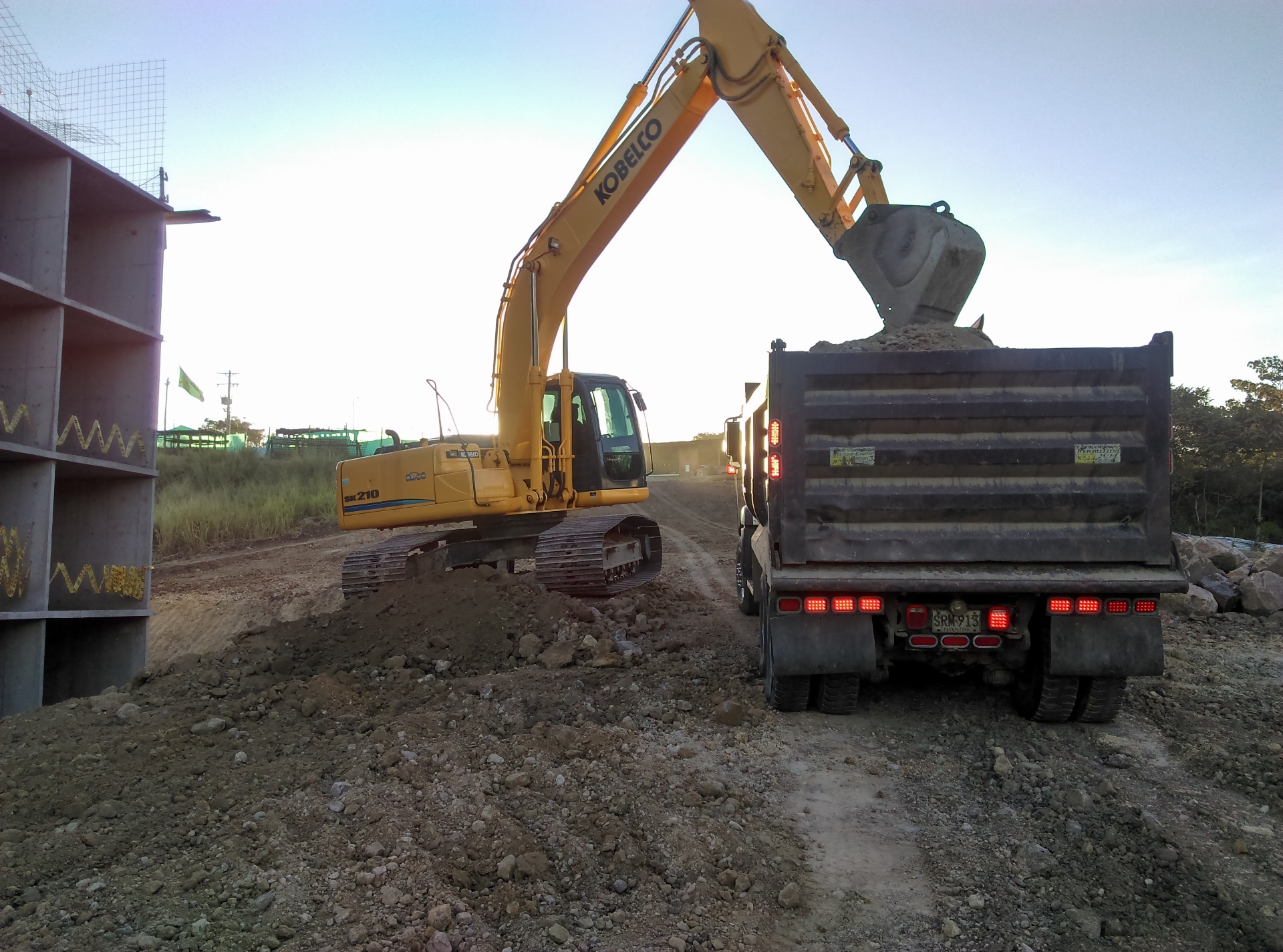 Excavadora Kobelco SK210 cargando volqueta